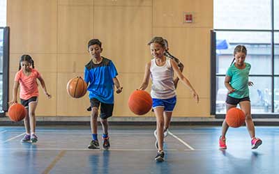 Children playing basketball in a gymnasium